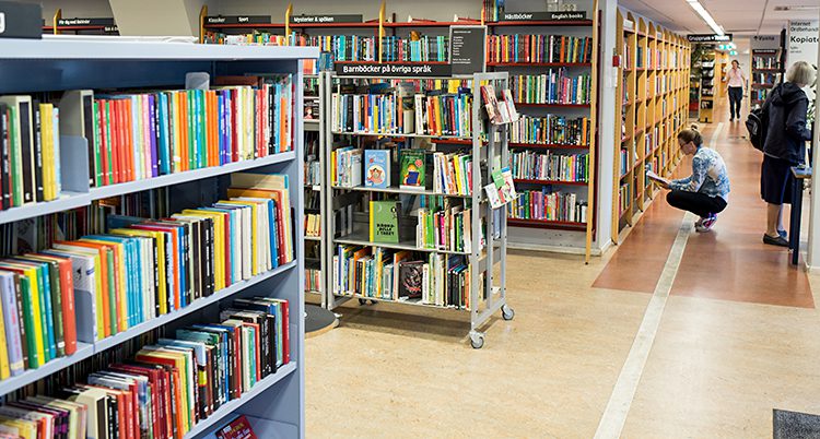 Flera hyllor med böcker på ett bibliotek.