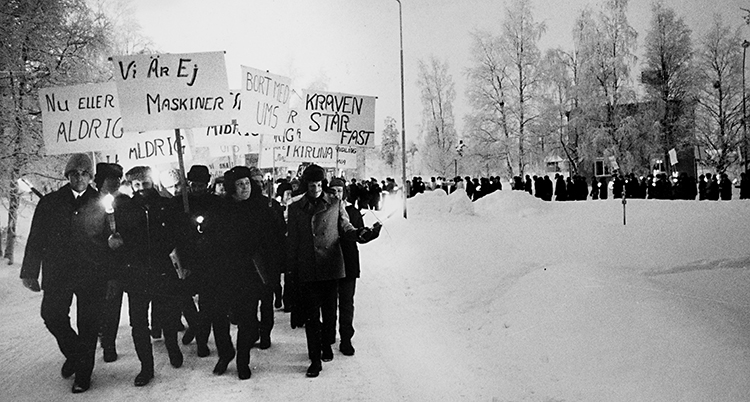 De går i tåg med plaket där det bland annat står Vi är inte maskiner.