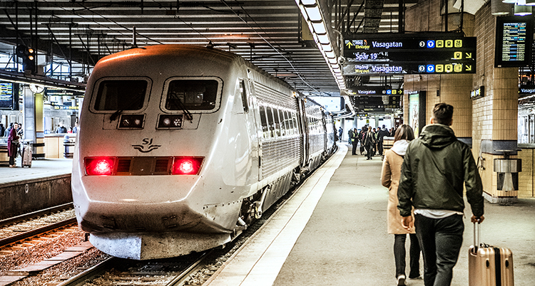 Ett tåg och människor på Stockholm centralstation.