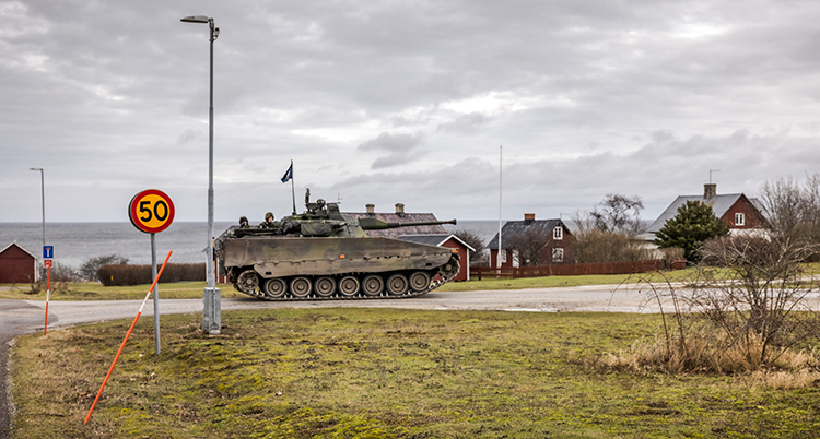 En bandvagn med militärer på en väg på Gotland.
