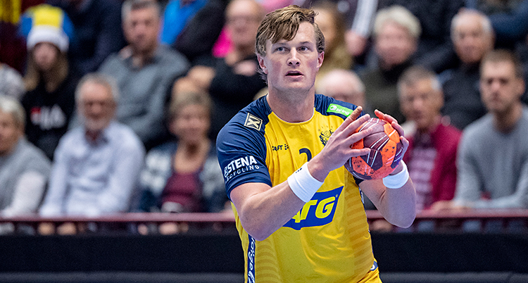Från en match i handboll. En man håller i bollen.