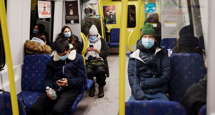 Människor i en tunnelbanevagn med munskydd.