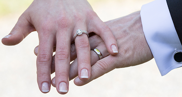 En närbild på en kvinnas hand och en mans hand. De har ringar på fingrarna. De har gift sig.