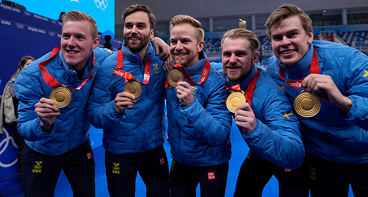 Fem män är glada och visar upp sina guldmedaljer.