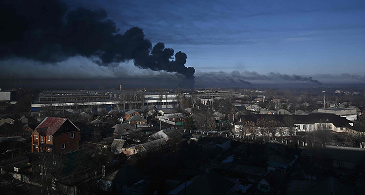 Ett foto av en stad. Längst bort syns svart rök som stiger mot himlen.