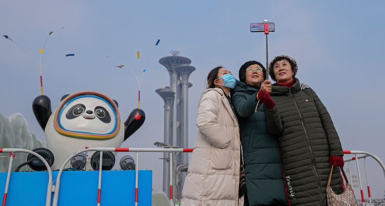 Tre kvinnor tar en bild framför de olympiska spelens maskot Bing Dwen Dwen.