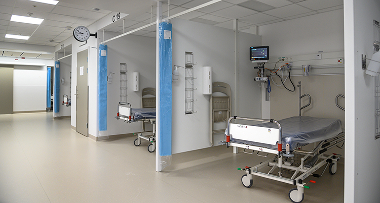 En korridor med bås med sjukhussängar