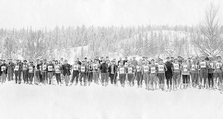 Många skidåkare står intill varandra på en svartvit bild