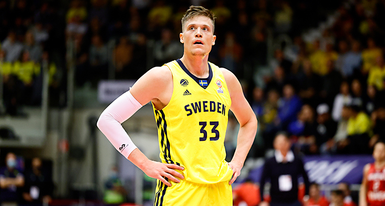 Från en match i basket. Jonas Jerebko har på sig gula kläder. Det står Sweden på hans linne.
