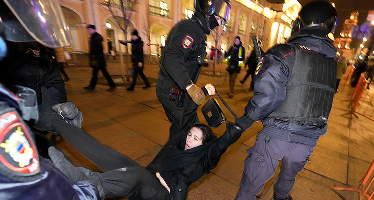 Poliserna drar i kvinnans armar och ben