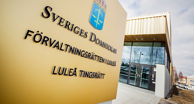 En bild som visar skylten utanför Luleå tingsrätt, och i bakgrunden syns byggnaden.