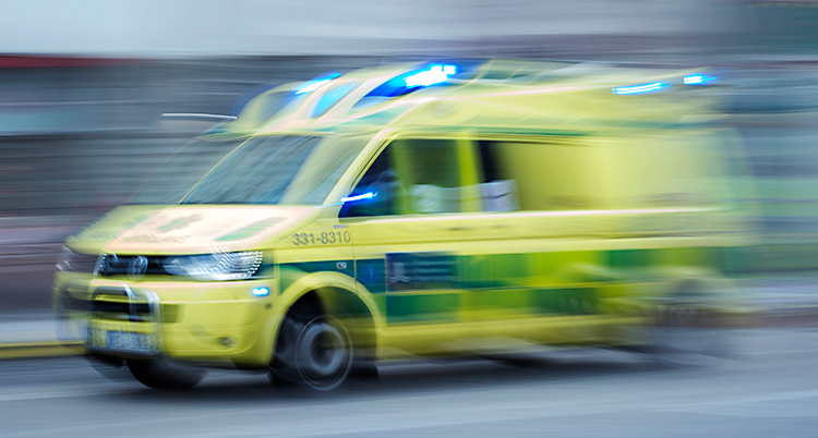 En ambulans som kör. Bilden är suddig för att visa att ambulansen är i rörelse.