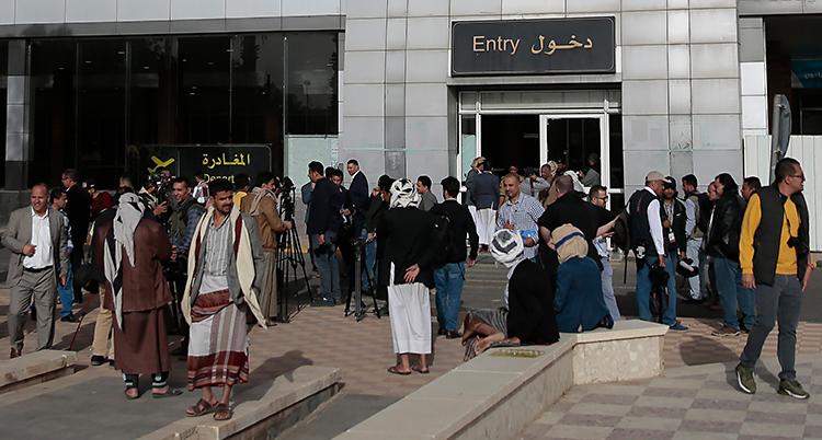 En grupp människor står samlade utanför en byggnad.