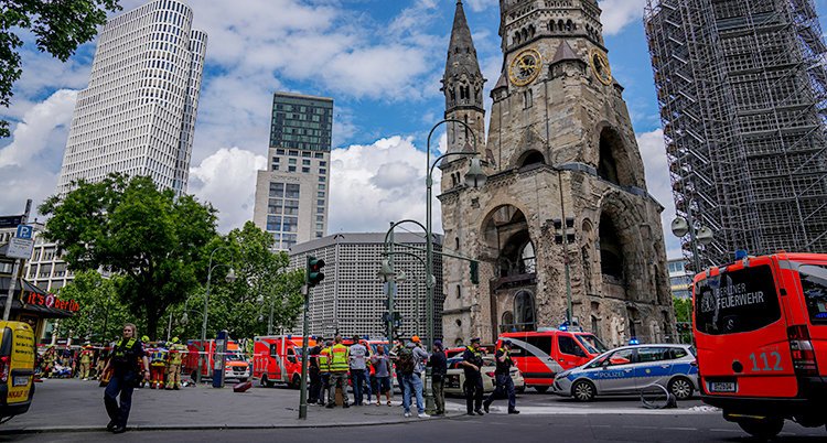 Poliser, sjukvårdare, räddningsarbetare och deras bilar är på en gata i Berlin.