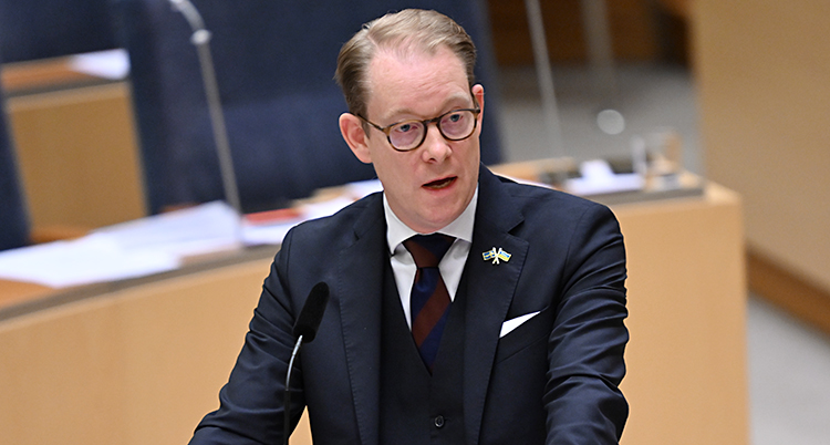 Han står och pratar i riksdagen.