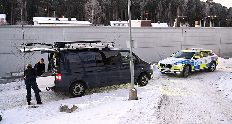 En mindre svart buss och en polisbil.