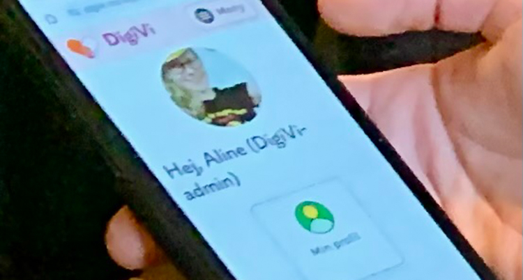 En hand håller i en telefon där appen syns
