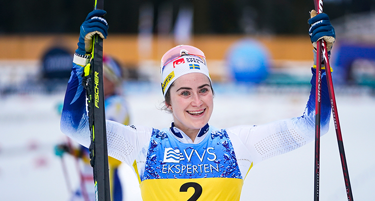 Ebba håller upp sina skidor efter en tävling.