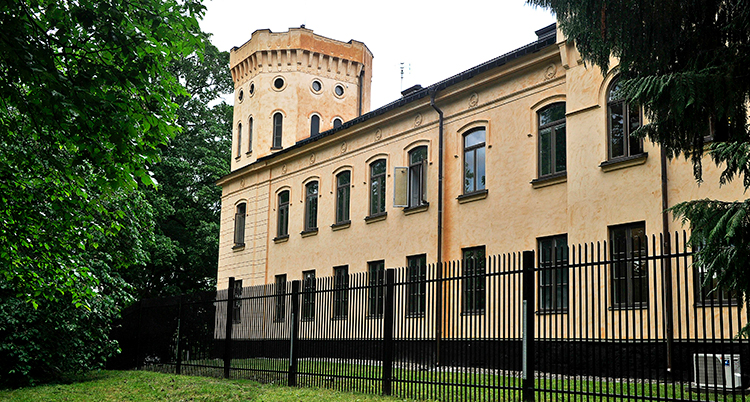Ett långt gult hus med ett torn. Det liknar en del av ett slott.