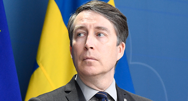Ett porträtt av Jomshof framför en svensk flagga.