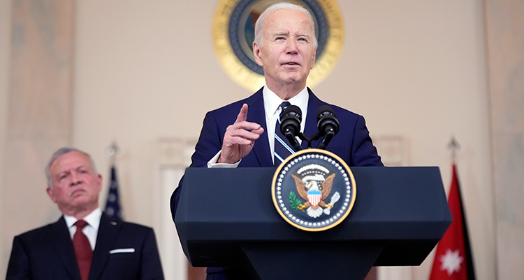 Joe Biden pratar. Kungen står bakom.