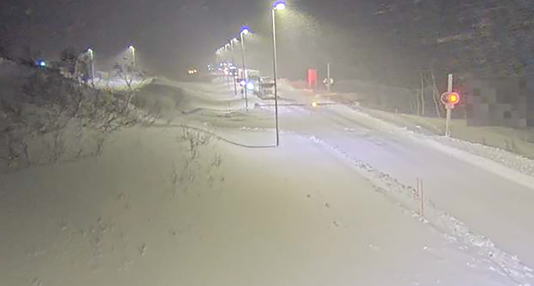 Det blåser och är snöigt. Vägen ser tom ut.