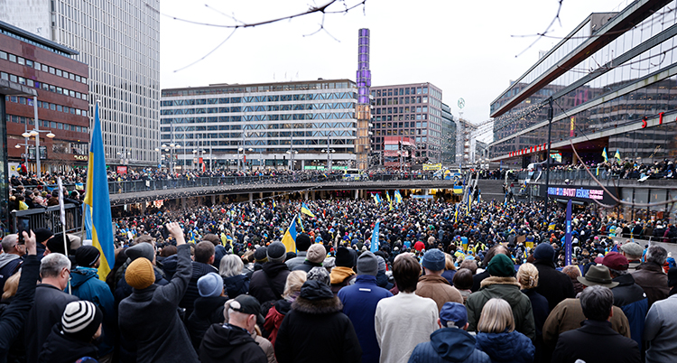 Massor av människor står på torget.