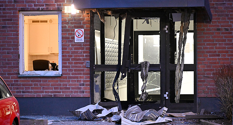 Porten till ett hus är trasig efter en explosion.