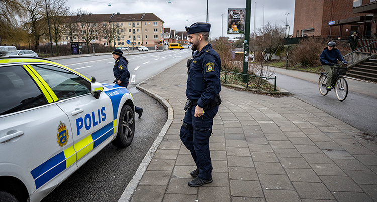 Poliser på väg till en polisbil.
