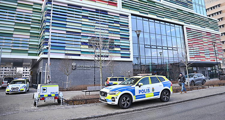 Flera polisbilar står på gatan utanför domstolen.