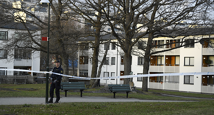 Poliserna har spärrat av vid några hus. En polis står och vaktar.