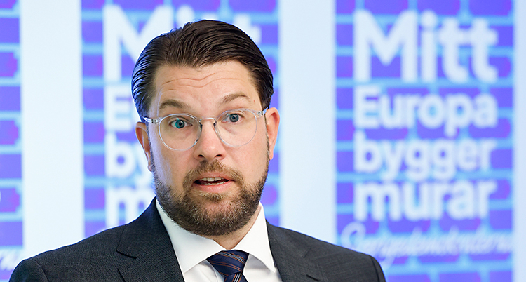 Han står och pratar på en träff med journalister.