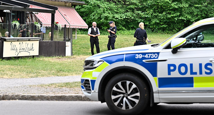 Poliser pratar med en man framför en restaurang.