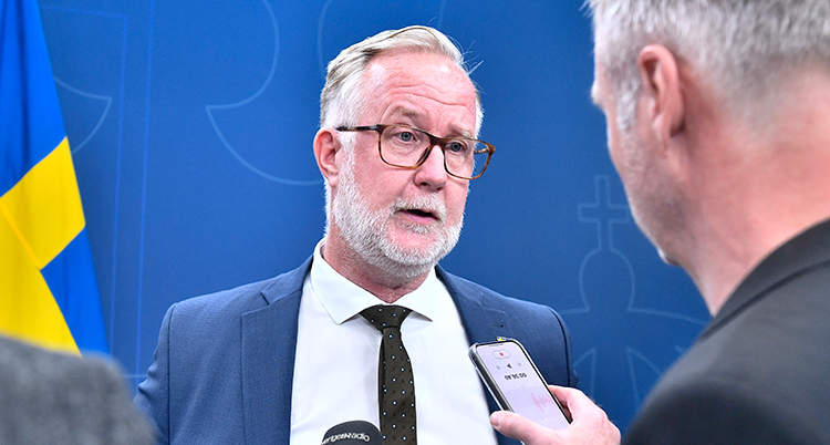 Han pratar med en person som sträcker fram en mikrofon.