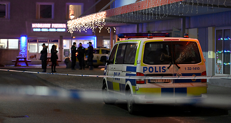 Det är mörkt ute. Poliserna har spärrat av utanför en restaurang. Bakom avspärrningen syns poliser och polisbilar.