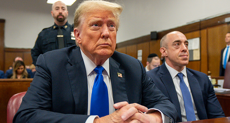 Trump i domstolen. Han lutar sig fram vid bordet han sitter vid.