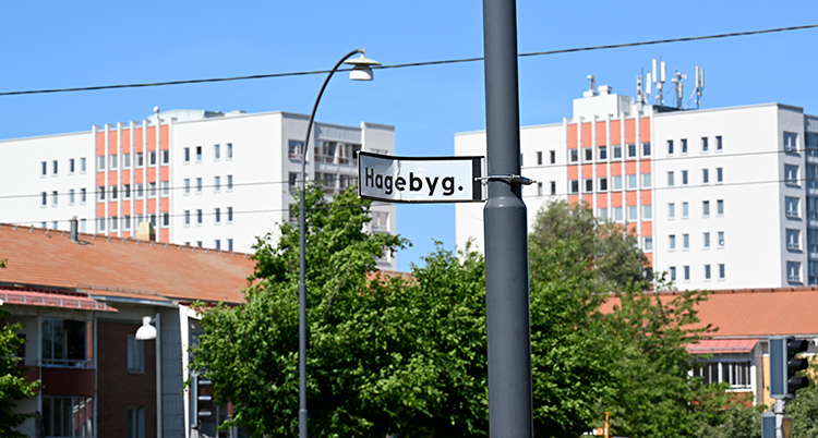 Flera höga hus syns mot en blå himmel.