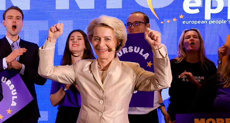 von der Leyen sträcker armarna i luften och skrattar.