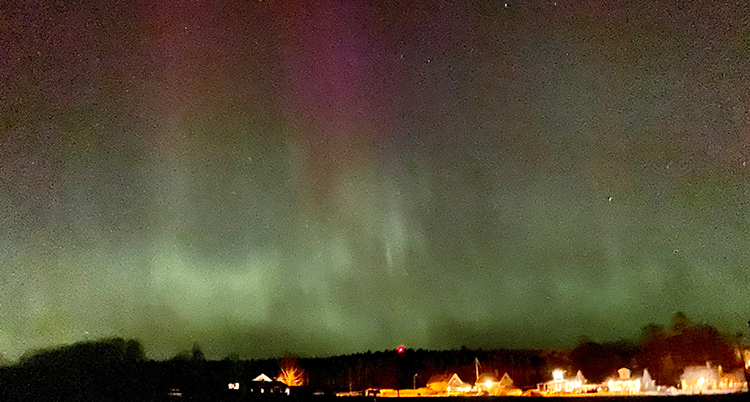 En mörk himmel med ljussken i grönt och rosa.